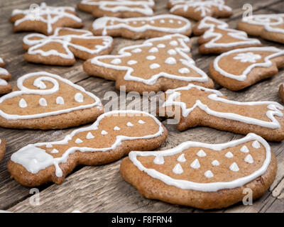 Forme différente gingerbread cookies de Noël avec glaçage blanc en bois placées sur les conseils rustique Banque D'Images