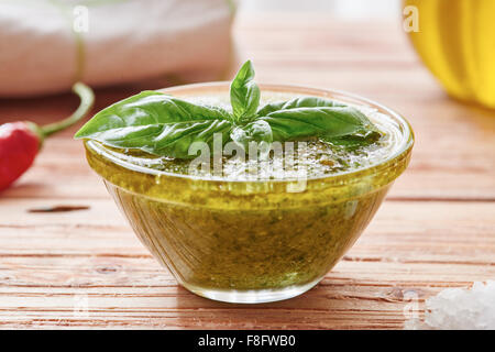 La sauce pesto sur table en bois entourée par des ingrédients Banque D'Images