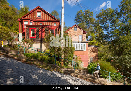 Un homme debout en face de deux maisons sur Canton Avenue dans le quartier de Beechview Pittsburgh, Pennsylvanie, USA. Banque D'Images