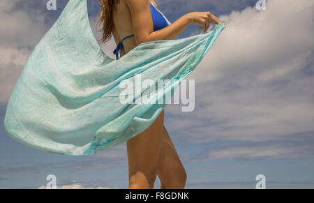 Hispanic woman holding sarong blowing in wind Banque D'Images