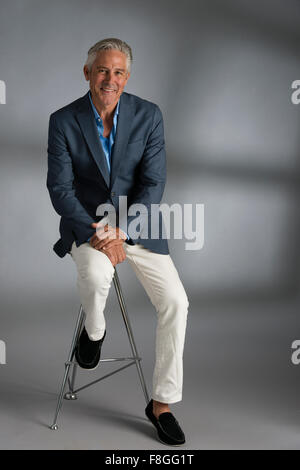 Caucasian businessman smiling on stool Banque D'Images