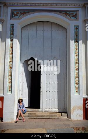 Assis sur le tourisme sunny pas d'un grand bâtiment de style colonial dans la province de Sancti Spiritus Cuba Trinidad Banque D'Images