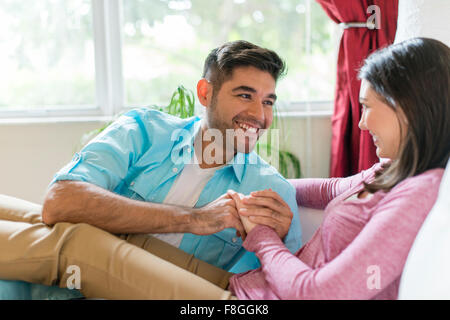 Hispanic couple relaxing on sofa Banque D'Images