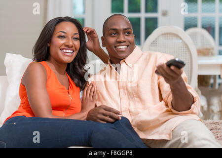 Couple watching television on sofa Banque D'Images