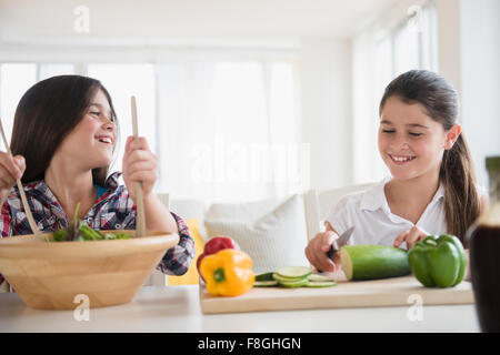 Caucasian twin sisters preparing salad Banque D'Images