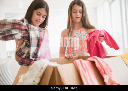 Portrait des soeurs jumelles faisant don de vêtements Banque D'Images