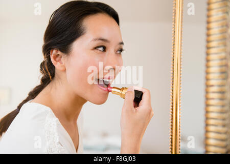 Chinese woman applying lipstick Banque D'Images