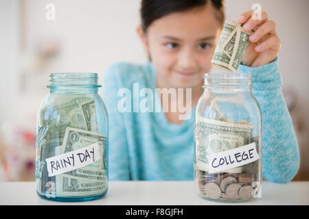 Fille d'économiser de l'argent dans le fonds du collège Banque D'Images