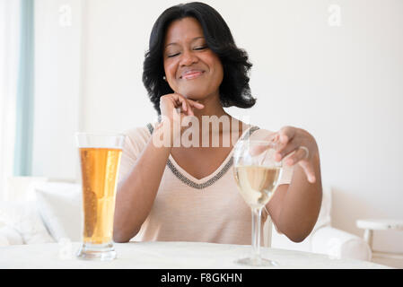 Femme noir choisir entre bière et vin blanc Banque D'Images