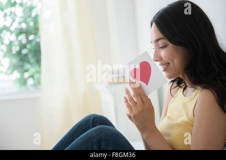 Hispanic woman reading carte romantique Banque D'Images