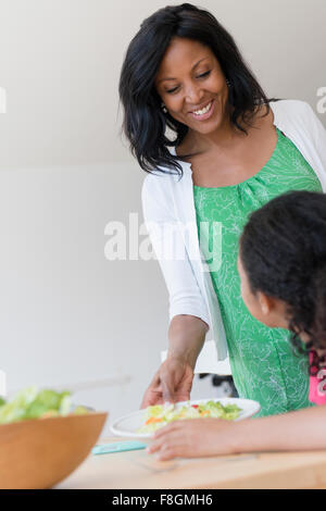 Mère fille servant salad Banque D'Images