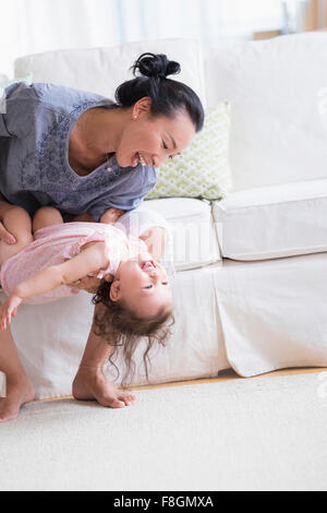 Mère et bébé fille jouer sur canapé Banque D'Images