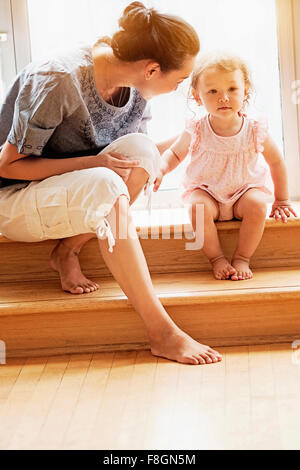 Mère et fille bébé sitting on steps Banque D'Images