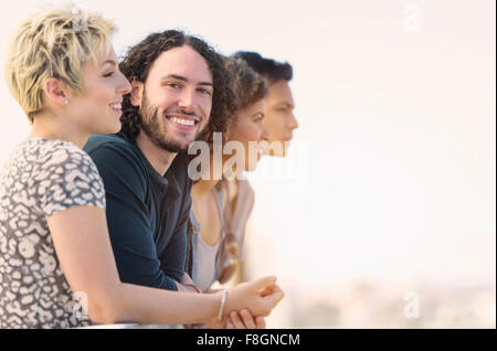 Man smiling avec des amis à l'extérieur Banque D'Images