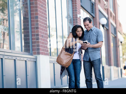 Young Woman using cell phone outdoors Banque D'Images