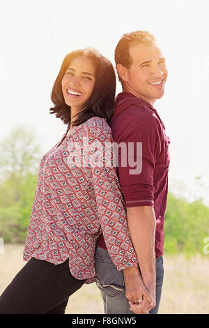 Hispanic couple standing back to back Banque D'Images