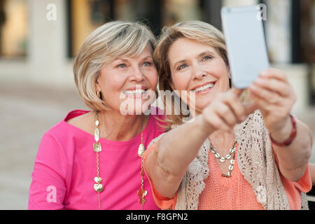 Les femmes de race blanche en tenant avec selfies cell phone Banque D'Images