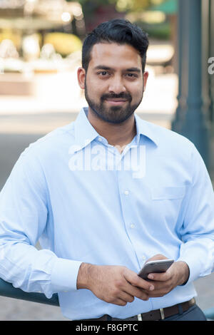 Indian businessman using cell phone in city Banque D'Images