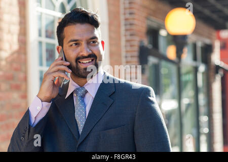 Indian businessman talking on cell phone in city Banque D'Images