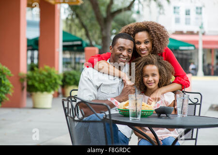 Family smiling at outdoor restaurant table Banque D'Images