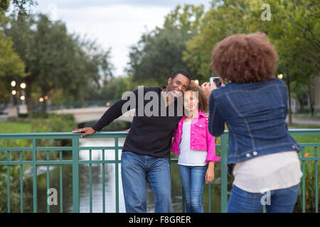 Mère photographing family on bridge Banque D'Images