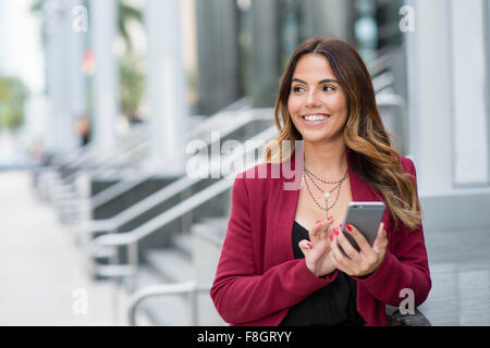 Hispanic businesswoman using cell phone Banque D'Images