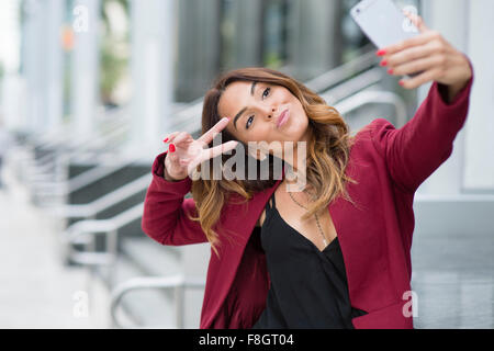 Hispanic businesswoman en tenant l'extérieur selfies Banque D'Images