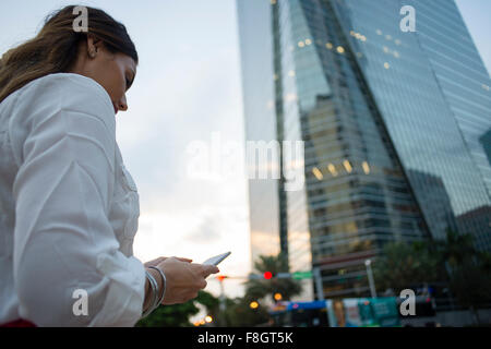 Hispanic businesswoman using cell phone Banque D'Images