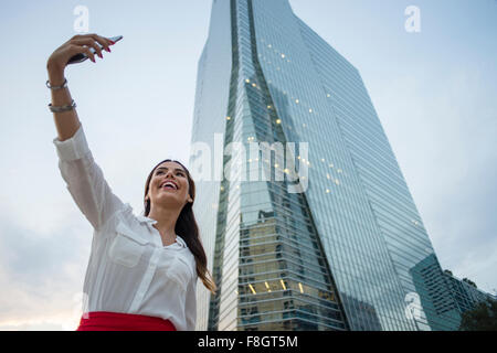 Hispanic businesswoman en tenant l'extérieur selfies Banque D'Images