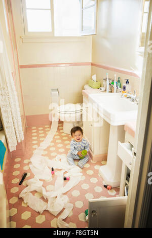 Bébé Garçon jouant dans une salle de bains privative malpropre Banque D'Images