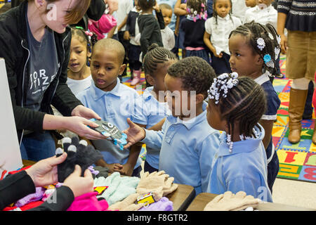 Detroit, Michigan, USA. 9 décembre 2015. Les enfants à l'école élémentaire Dossin recevoir mitaines d'un organisme de bienfaisance appelé mitaines pour Detroit. L'organisme distribue des mitaines pour 26 000 élèves du primaire des écoles publiques de Detroit ; la plupart ont été donnés par les employés de Fiat Chrysler Automobiles. Crédit : Jim West/Alamy Live News Banque D'Images