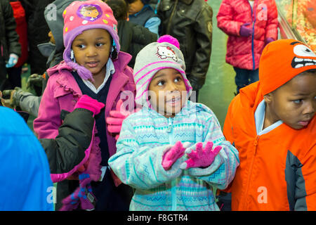 Detroit, Michigan, USA. 9 décembre 2015. Les enfants à l'école élémentaire Dossin habillé pour aller à l'extérieur de l'aire de nouveau porter des mitaines qu'ils ont reçu d'un organisme de bienfaisance appelé mitaines pour Detroit. L'organisme distribue des mitaines pour 26 000 élèves du primaire des écoles publiques de Detroit ; la plupart ont été donnés par les employés de Fiat Chrysler Automobiles. Crédit : Jim West/Alamy Live News Banque D'Images