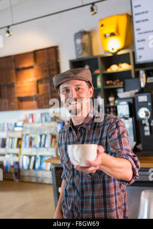 Servir le café barista caucasienne dans cafe Banque D'Images