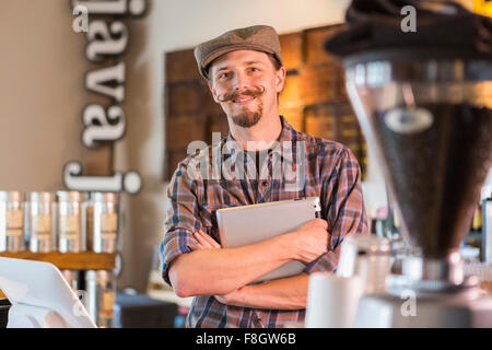 Caucasian barista holding digital tablet in cafe Banque D'Images