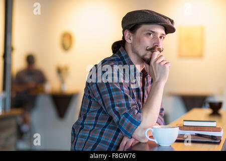 Young man thinking in cafe Banque D'Images