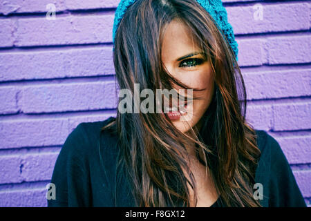 Caucasian woman à purple brick wall