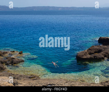 Hispanic woman floating in ocean Banque D'Images