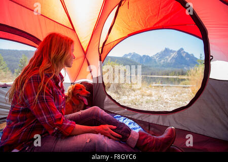 Caucasian woman and dog dans tente de camping Banque D'Images