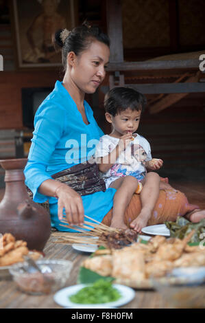 Asian mother and son eating sur tapis tissé Banque D'Images