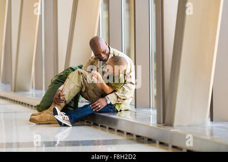 Soldat afro-américain et son fils parler in airport Banque D'Images