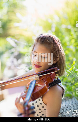 Mixed Race musician playing violin outdoors Banque D'Images