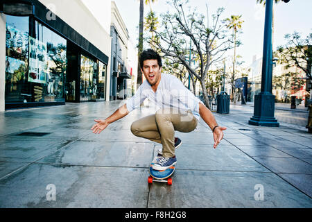 Caucasian man riding skateboard Banque D'Images