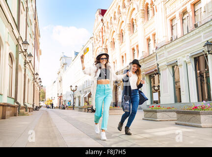 Deux filles sautant joyeusement en marchant Banque D'Images