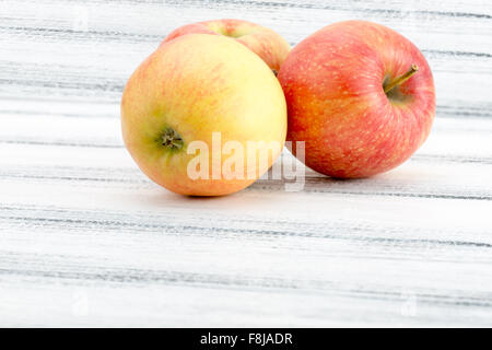 Pommes rouges sur le fond en bois blanc. Banque D'Images