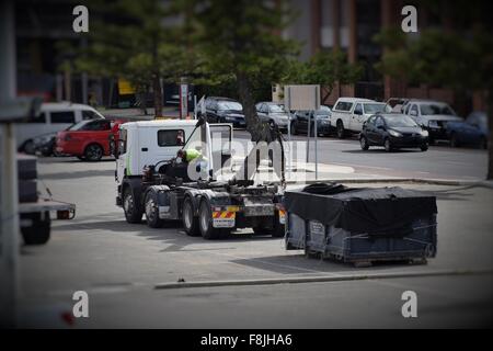 Dans la ville de camions ramasser des conteneurs en acier à l'aide d'une grue Banque D'Images