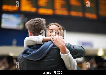 Heterosexual couple hugging at gare, vue arrière Banque D'Images