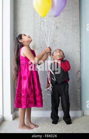 Jeune fille et garçon, holding balloons Banque D'Images