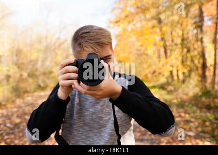 Portrait of teenage boy de photographier à la forêt d'automne Banque D'Images