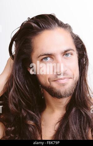 Portrait de jeune homme aux cheveux longs, close-up Banque D'Images
