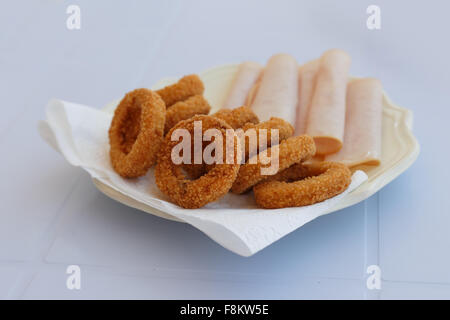 Close up en détail vue avant d'une plaque de base de l'oignon frit avec jambon servi sur une assiette. Banque D'Images